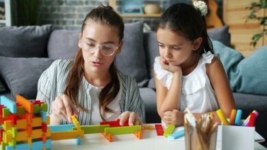 طفلة تلعب بألعاب تعليمية منزلية مع والدتها لتنمية مهارات التعلم والتركيز